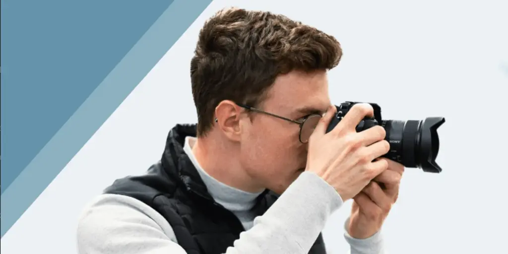 Simon Kahner fotografiert mit der Kamera am Auge