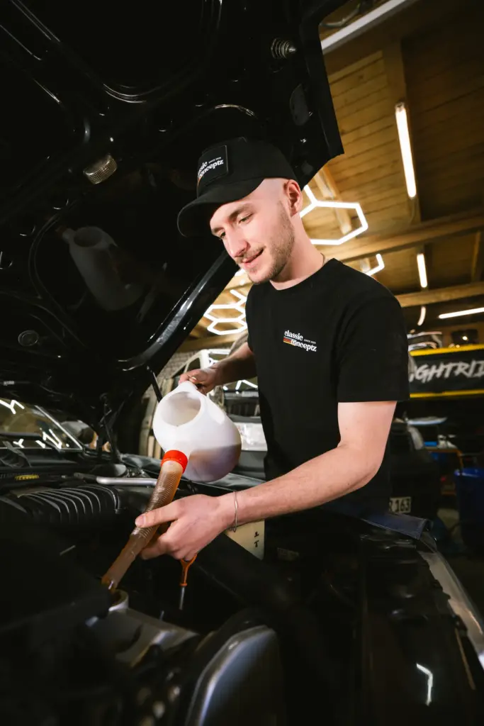 Mechaniker füllt Kühlwasser nach