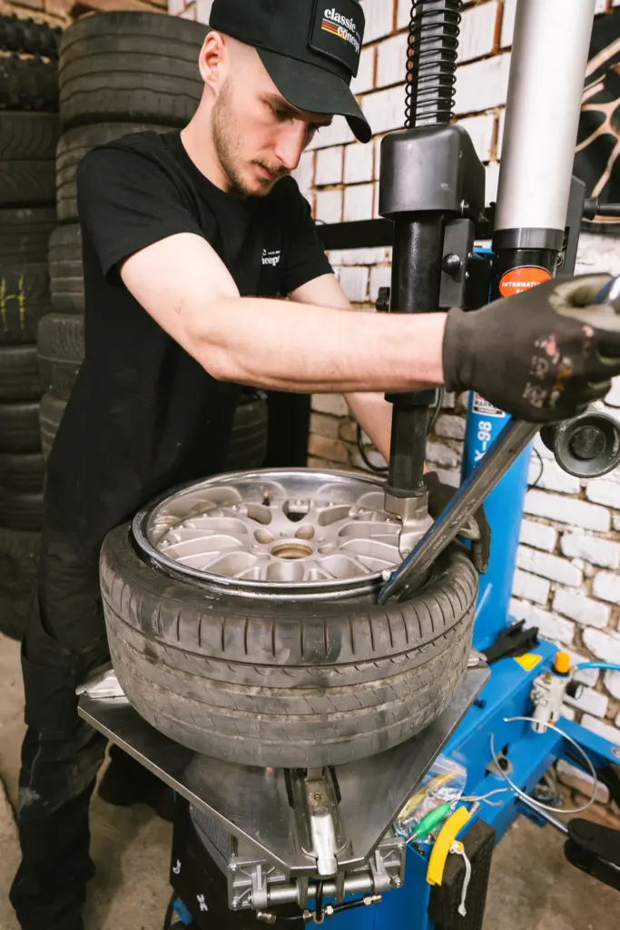 Mechaniker an der Reifenmontiermaschine