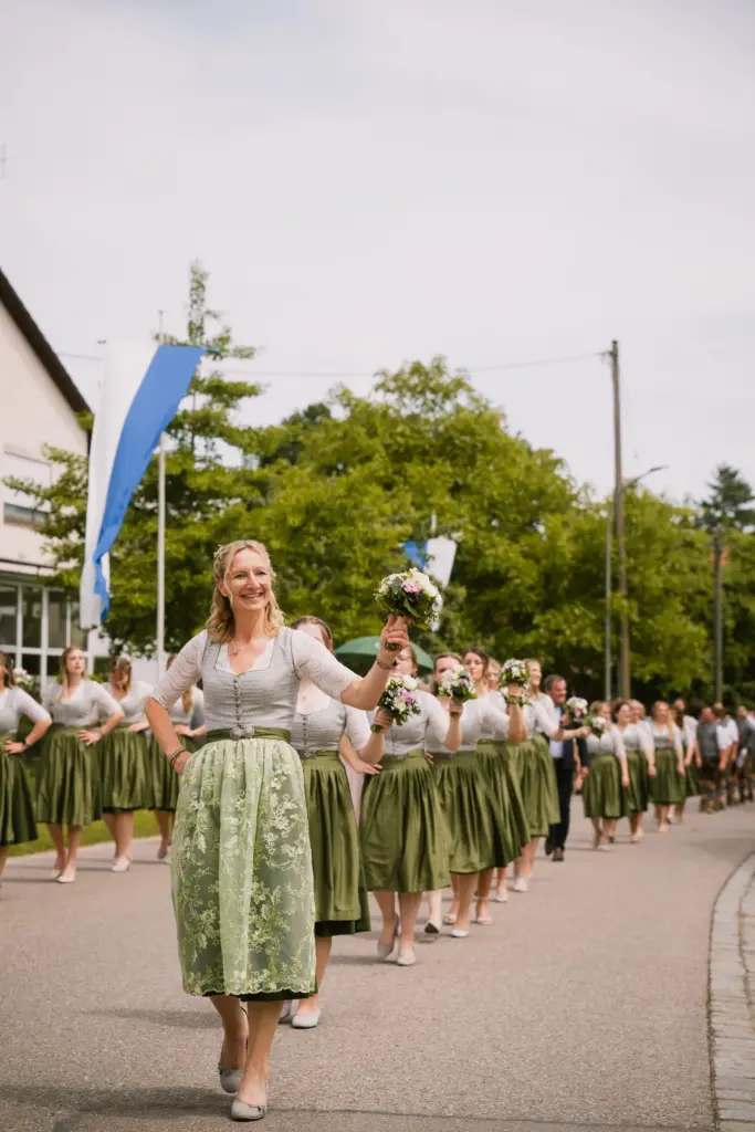 Frau im Dirndl führt den Festzug an