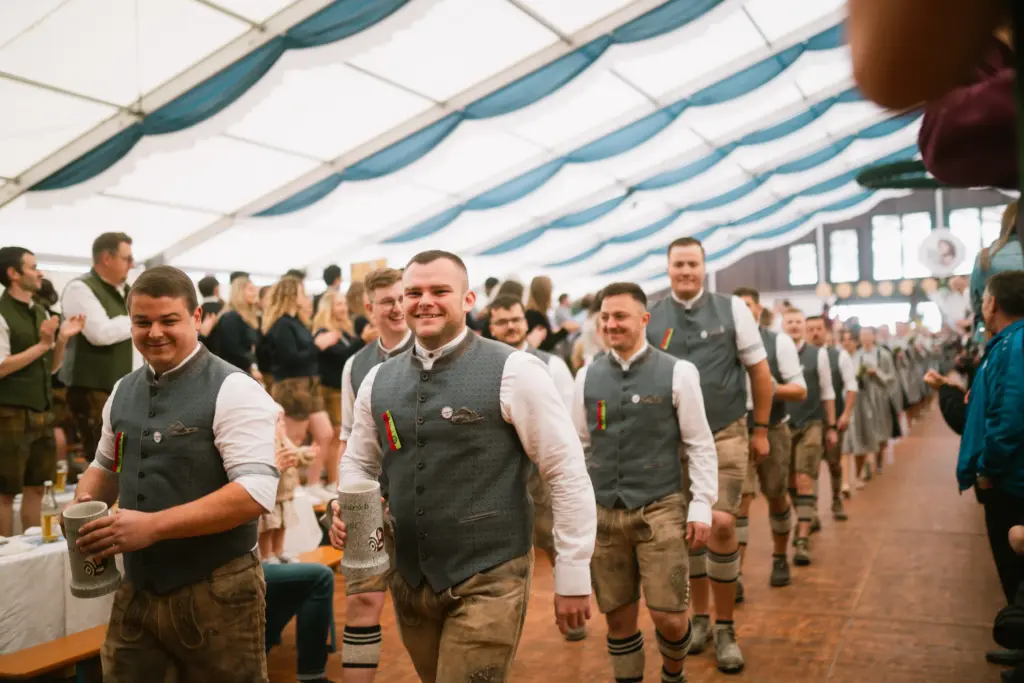 Burschen in Tracht ziehen ins Festzelt ein