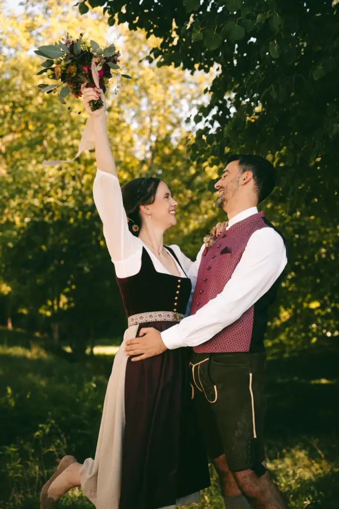 Jubelndes Brautpaar mit Brautstrauß