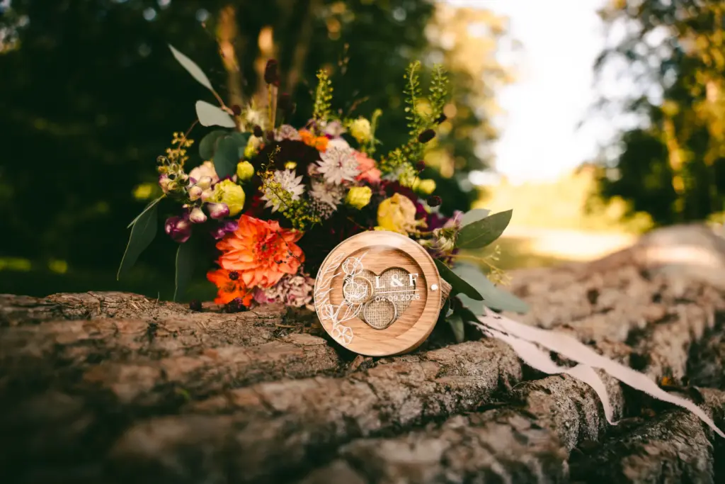 Eheringe mit Blumen auf einem Baumstamm