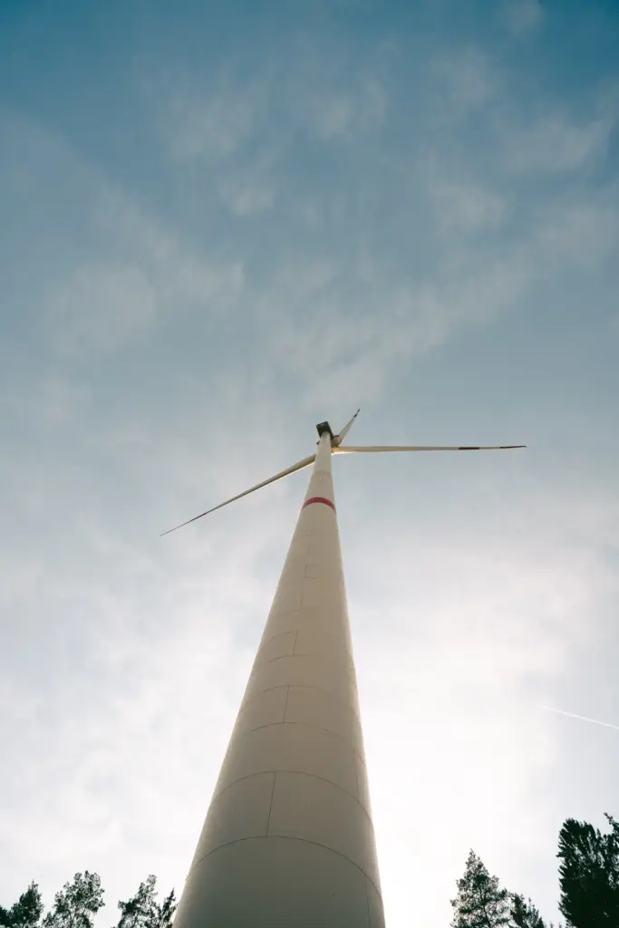 Turm eines Windrads vor bewölktem Himmel