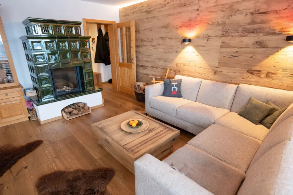 Wohnbereich mit Kachelofen in einem Chalet, Koid Holzbauelemente