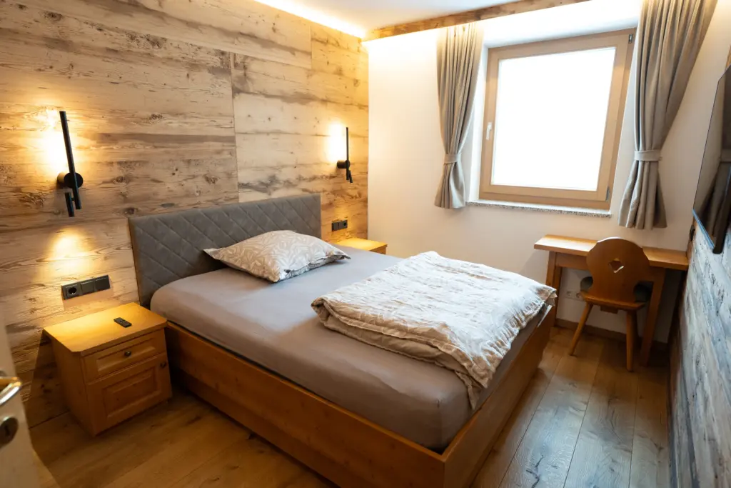 Schlafzimmer mit Holzverkleidung in einem Chalet, Koid Holzbauelemente