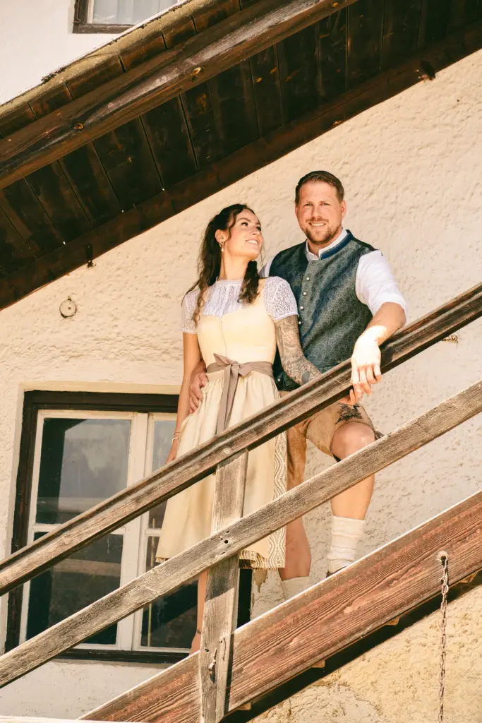 Paar in Tracht auf einer Holztreppe, Shooting für Trachten Dieser