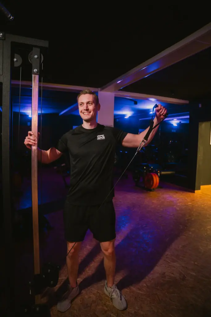 Trainer am Kabelzug im blauen Licht